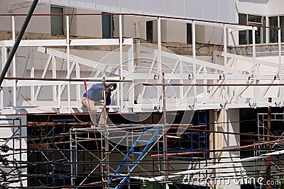 Worker welds on top of a scaffold Editorial Stock Photo