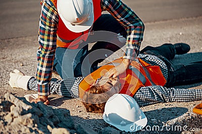 Worker in white helmet checking life functions of an injured man Stock Photo