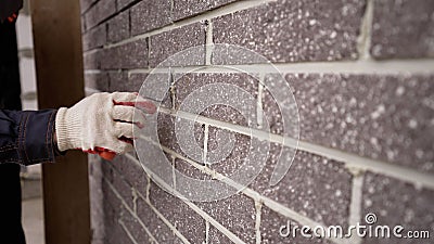 The builder carefully makes a brick wall, a close-up of a skilled craftsman laying a large masonry of bricks, the Stock Photo