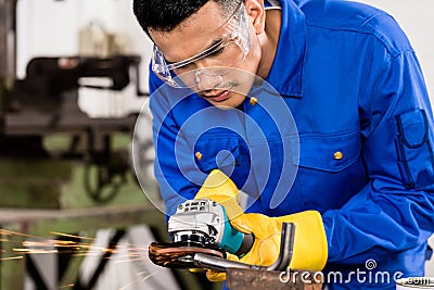 Worker working on metal with grinder tool Stock Photo
