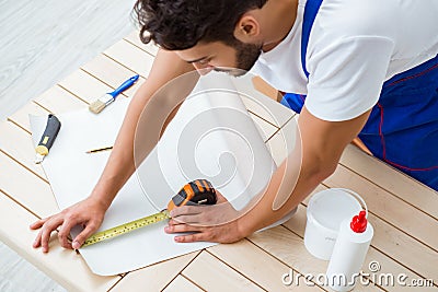 The worker working on wallpaper during refurbishment Stock Photo