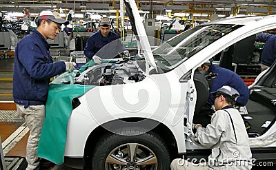 Workers assemble a car on assembly line in car factory Editorial Stock Photo