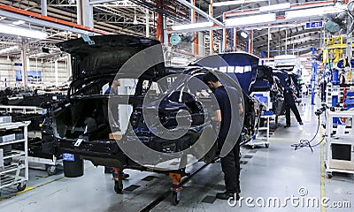 Workers assembles cars at automobile assembly line production plant Editorial Stock Photo