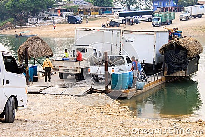 Workers in a boat with their vehicles waiting for cross the river in Guatemala Editorial Stock Photo