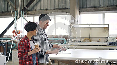 Workers Talking In Wood Workshop Guy Using Tablet While Girl Is Drinking Coffee