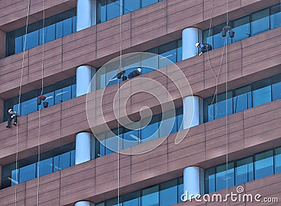 Workers cleaning a glass facade Editorial Stock Photo