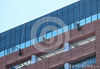 Workers cleaning a glass facade Editorial Stock Photo