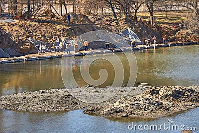 Workers clearing the lake and landscaping the park area Stock Photo