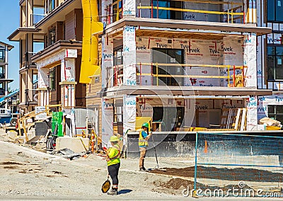 Workers On Constuction Site Working Together Teamwork Concept. People working on new development construction Editorial Stock Photo