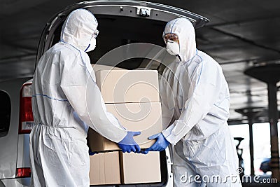 Workers in coronavirus hazmat suits delivering drugs Stock Photo