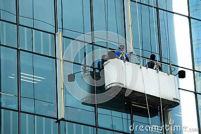Workers crane cradle clean windows glass of high Editorial Stock Photo