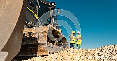 Workers discussing their job in quarry or gravel pit Stock Photo