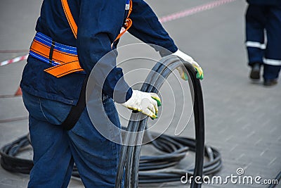 Workers dismantle the telecommunication cable in the well Stock Photo