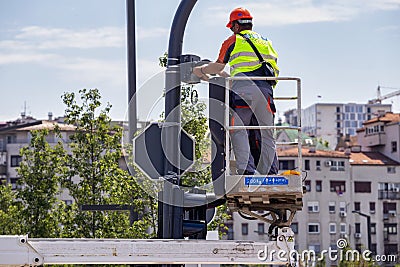 Workers at elevator platform placing surveillance camera Editorial Stock Photo