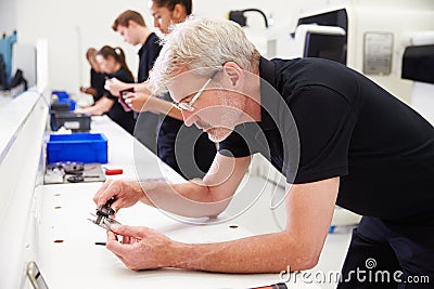 Workers In Engineering Factory Checking Component Quality Stock Photo