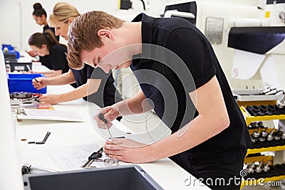 Workers In Engineering Factory Checking Component Quality Stock Photo