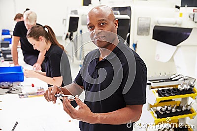 Workers In Engineering Factory Checking Component Quality Stock Photo