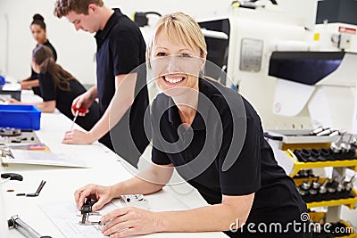 Workers In Engineering Factory Checking Component Quality Stock Photo