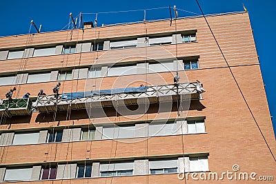 Workers on the exterior scaffold elevator to repair the building Editorial Stock Photo