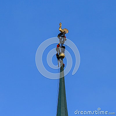 Workers fixing golden church spire Stock Photo
