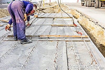 Workers are helping on ground, mobile crane is carry cement slab Editorial Stock Photo