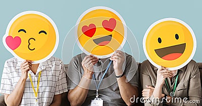 Workers holding happy face emojis Stock Photo