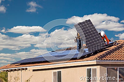 Workers Installing Solar Panels on House Roof Stock Photo