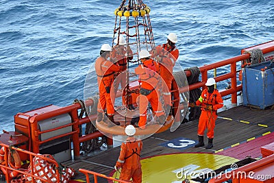 Workers are lifted by the crane to the offshore platform Editorial Stock Photo