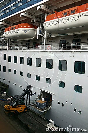 Workers loading cargo into passenger liner ship Editorial Stock Photo