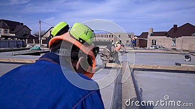 Workers make measurements measuring tape on construction. Clip. Builders in uniform and hard hat working on construction Editorial Stock Photo