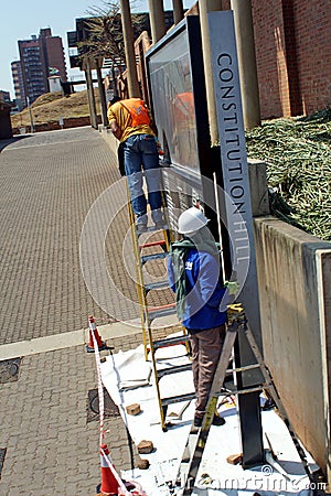 Workers painting a sing on Constitution Hill Editorial Stock Photo