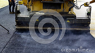 Worker distributes on the edge the asphalt laid Stock Photo
