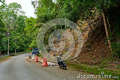 Workers reinforce the mountainside to prevent landslides on the road Editorial Stock Photo