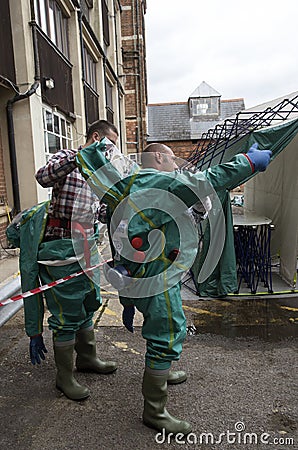 Workers removing decontamination suits Editorial Stock Photo