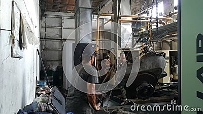 Workers repair of industrial machinery that is experiencing severe damage. Repair of compressor engines. Editorial Stock Photo