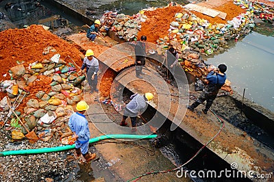 The workers are on the river drainage pipeline maintenance Editorial Stock Photo