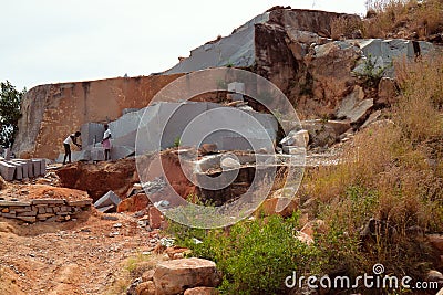Workers separated huge piece of shale rock and make from it square stone Editorial Stock Photo