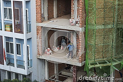 Workers are setting the electricty up in the wall of a bricks building in Vietnam Editorial Stock Photo