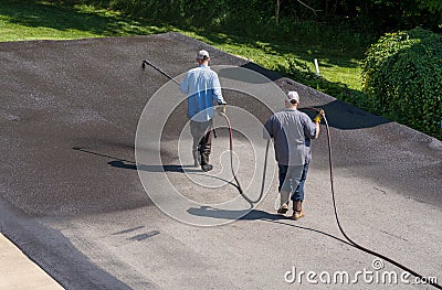 Workers spraying blacktop or asphalt sealer onto roadway Editorial Stock Photo