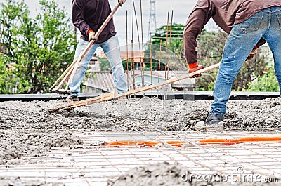 Workers spreading concrete over the slab Stock Photo