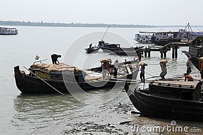 Workers unload cargo from the boat in Gosaba, India Editorial Stock Photo
