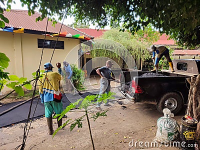 workers unloading asphalt from cars onto the road Editorial Stock Photo