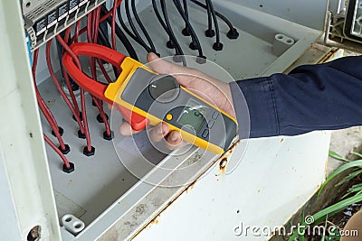 Workers use Clamp meter to measure the current of electrical wires produced from solar energy for confirm to systems working Stock Photo