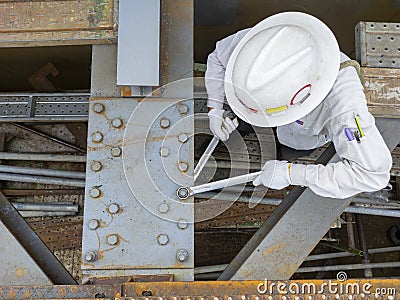 Workers are using a wrench to torque bolts to hold the splice plate to the steel beam of steel structure work Stock Photo