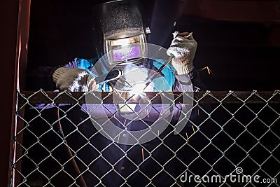 Workers are welding steel mesh in the work area. Stock Photo