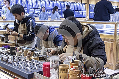 Workers work on the silver jewelry as gift for tourists in Shanghai Yuyuan, China Editorial Stock Photo