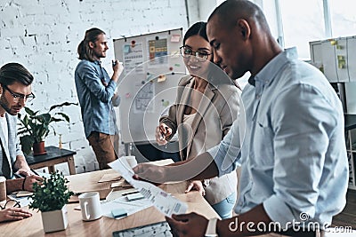 Working as team. Group of young business people communicating wh Stock Photo