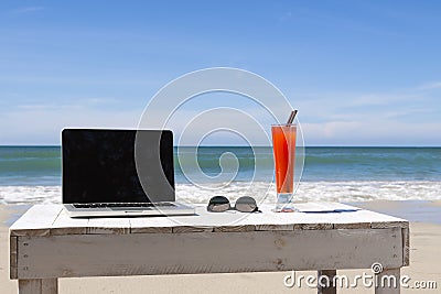 Working on the beach with laptop, freelancer traveling and remote work Stock Photo