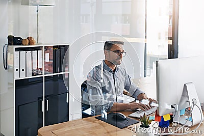 Always working on bettering his online presence. a businessman working on his computer at his desk. Stock Photo