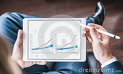 Working businessman investor,trader.Financial report,presenatation in tablet.Diagram gantt chart, analytics,project profit Stock Photo